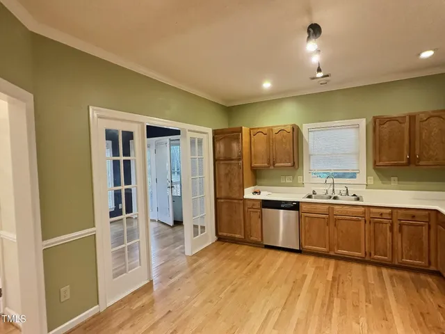 a large kitchen with stainless steel appliances granite countertop a lot of counter space and wooden floor