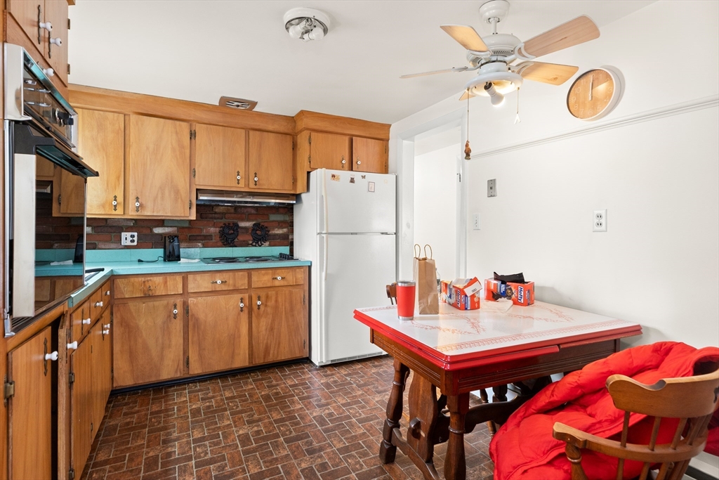 15 Quebec Court Lynn, MA 01905 - Photo 11 of 23 a kitchen with stainless steel appliances granite countertop a sink a stove cabinets dining table and chairs