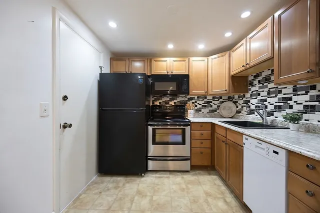 a kitchen with stainless steel appliances granite countertop a refrigerator and a sink