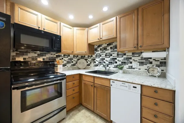a kitchen with stainless steel appliances granite countertop a sink stove and microwave
