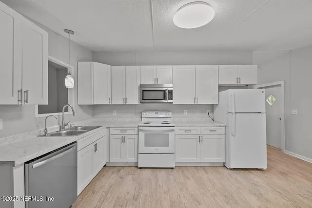 a kitchen with white cabinets and sink