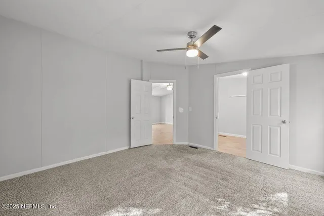 an empty room with fan and entrance