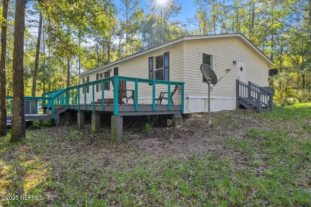 a view of a house with a yard and deck