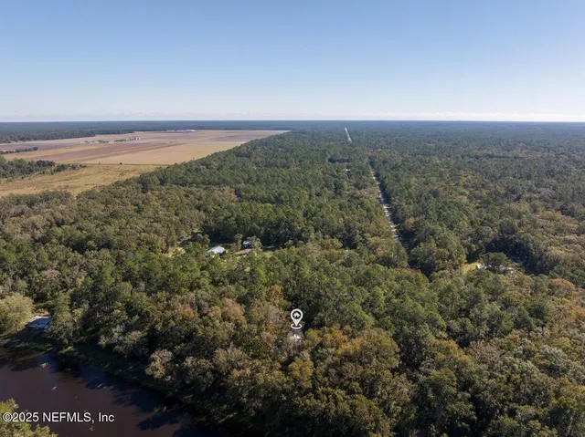 an aerial view of house with yard and mountain view in back