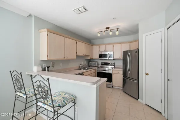 a kitchen with white cabinets sink and stainless steel appliances