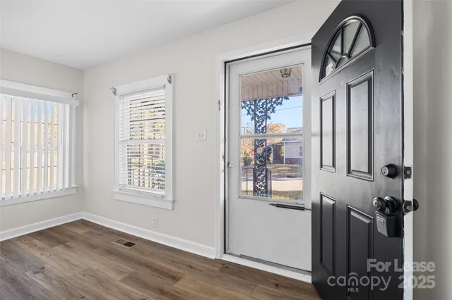 an empty room with wooden floor and a window