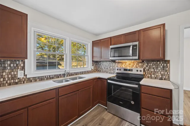 a kitchen with a sink stove and microwave