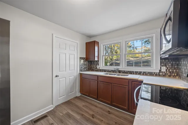 a kitchen with stainless steel appliances granite countertop a stove a sink and a refrigerator