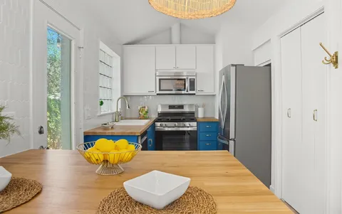 a kitchen with stainless steel appliances granite countertop a stove a refrigerator and a wooden floor