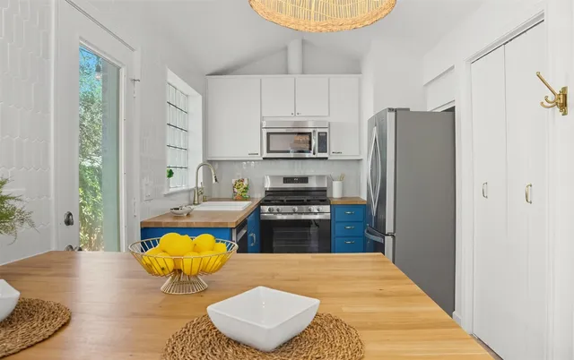 a kitchen with stainless steel appliances granite countertop a stove a refrigerator and a wooden floor