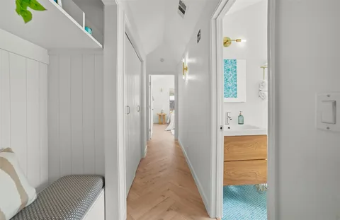 a view of a hallway with wooden floor and closet