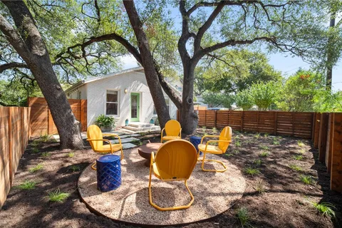 a backyard of a house with barbeque oven fire pit table and chairs
