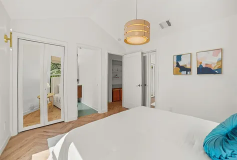 a bedroom with a bed and a painting on the wall