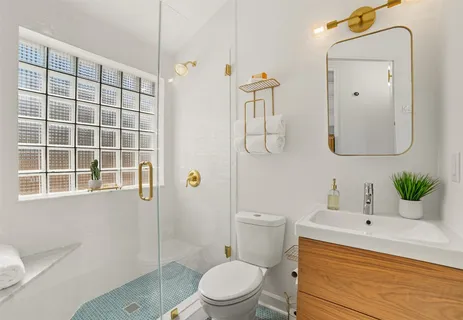 a bathroom with a sink a toilet and shower