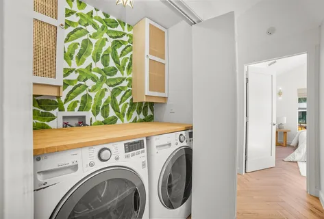 a view of washer and dryer with bathroom in the background