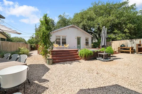 a view of a chairs and table in the back yard of the house