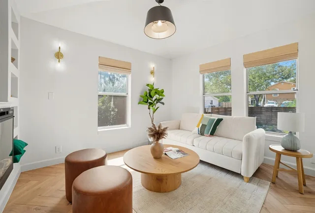 a living room with furniture a table and a large window