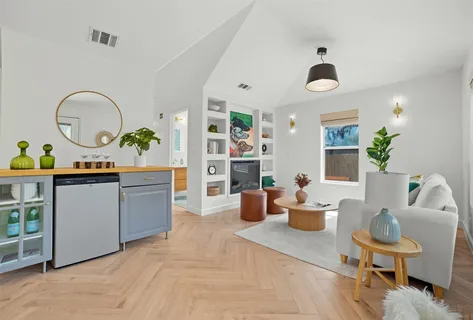 a living room with furniture a flat screen tv and kitchen area