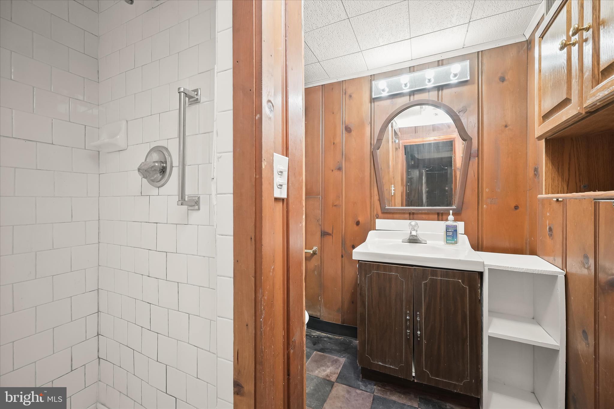 1509 Shadyside Road Baltimore, MD 21218 - Photo 30 of 38 a bathroom with a granite countertop sink a mirror and shower