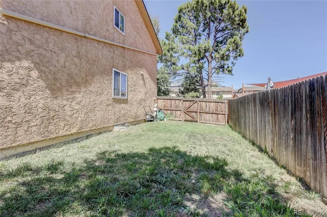 a backyard of a house with table and chairs