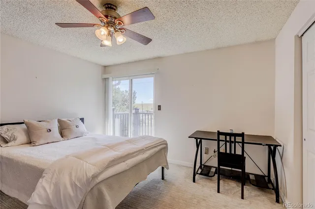 a bedroom with a bed and a chandelier fan