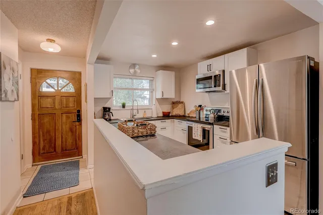 a kitchen with refrigerator and cabinets