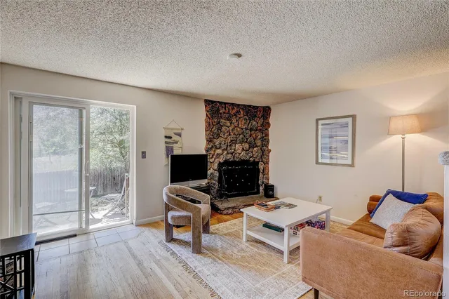 a living room with furniture a fireplace and a floor to ceiling window