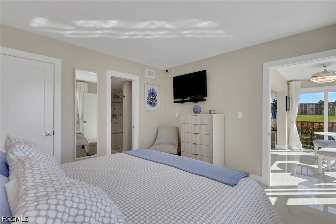 9 High Point Circle North, Unit 101 Naples, FL 34103 - Photo 20 of 49 a bedroom with a bed and a flat screen tv