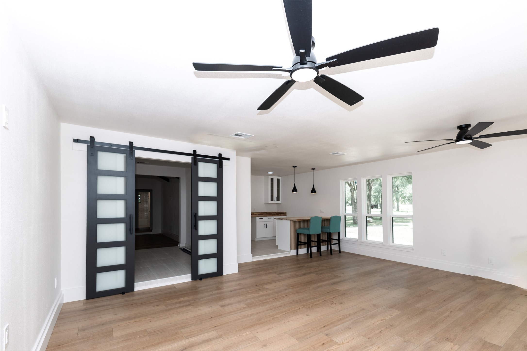205 Bello Circle Georgetown, TX 78628 - Photo 17 of 36 Wide plank hardwood floors complement the open layout, leading to a breakfast bar with pendant lights.