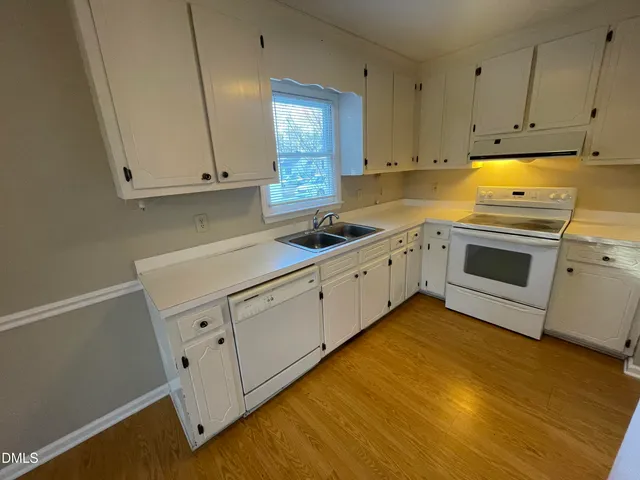 a kitchen with white cabinets and white appliances