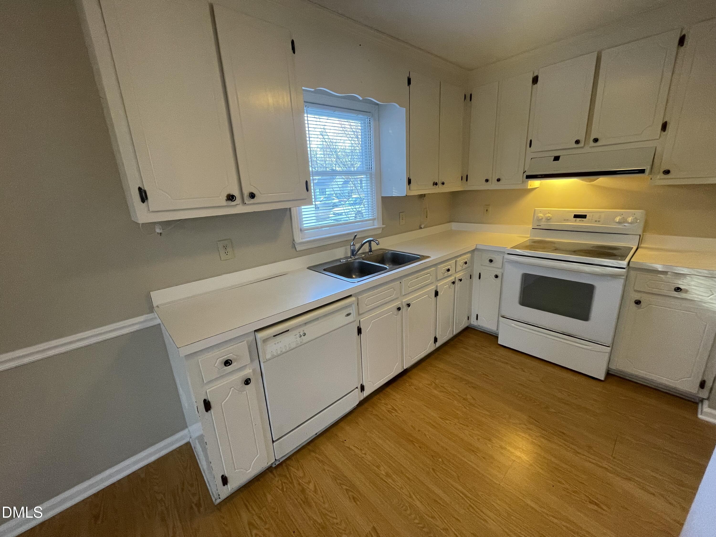 4116 Lodge Allen Court Raleigh, NC 27616 - Photo 12 of 20 a kitchen with white cabinets and white appliances