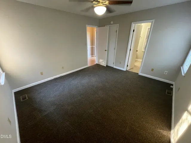 an empty room with windows and closet