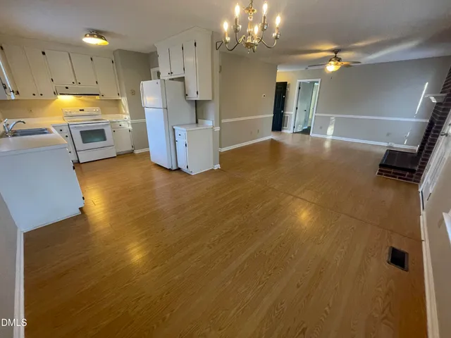 a view of a kitchen with a sink a refrigerator and window