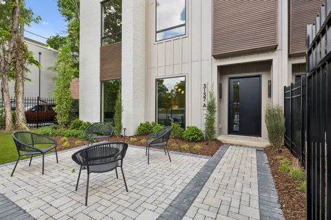 a view of a patio with table and chairs and potted plants and large tree