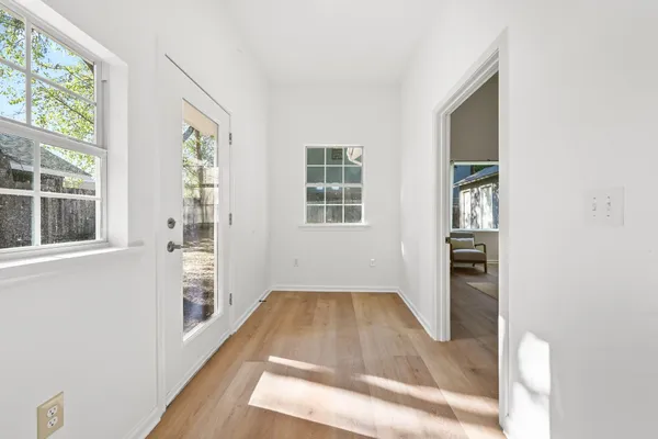an entryway with wooden floor and windows