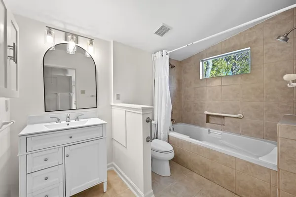 a spacious bathroom with a toilet sink and mirror