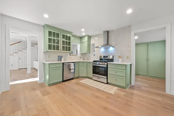 a kitchen with granite countertop a sink cabinets and stainless steel appliances