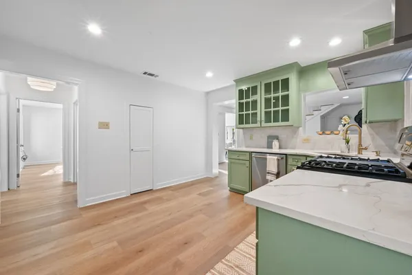 a kitchen with a sink a refrigerator and wooden floor