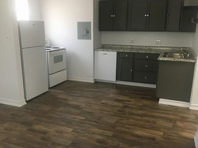 a kitchen with stainless steel appliances granite countertop a stove a sink and a refrigerator