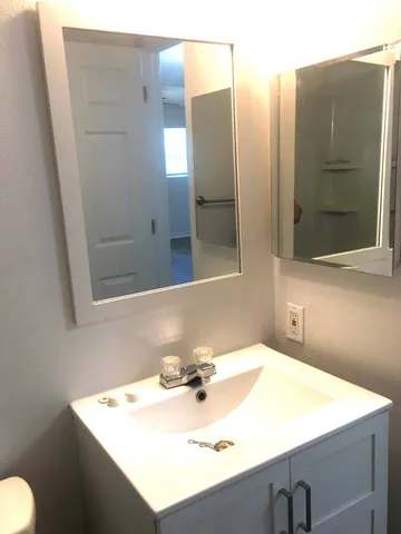 an empty room with wooden floor and cabinet