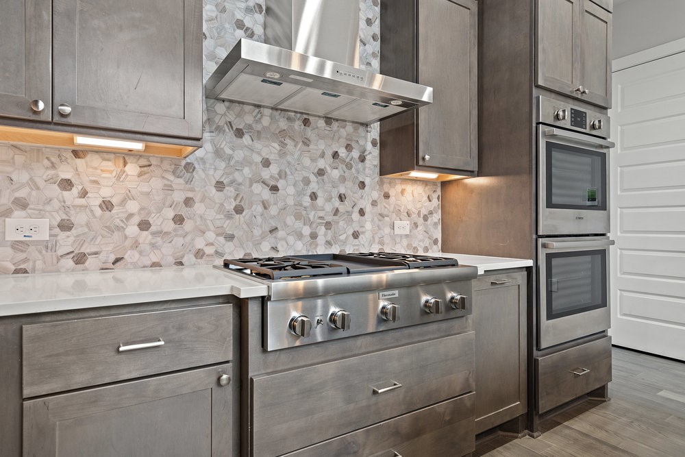 a stove top oven sitting inside of a kitchen