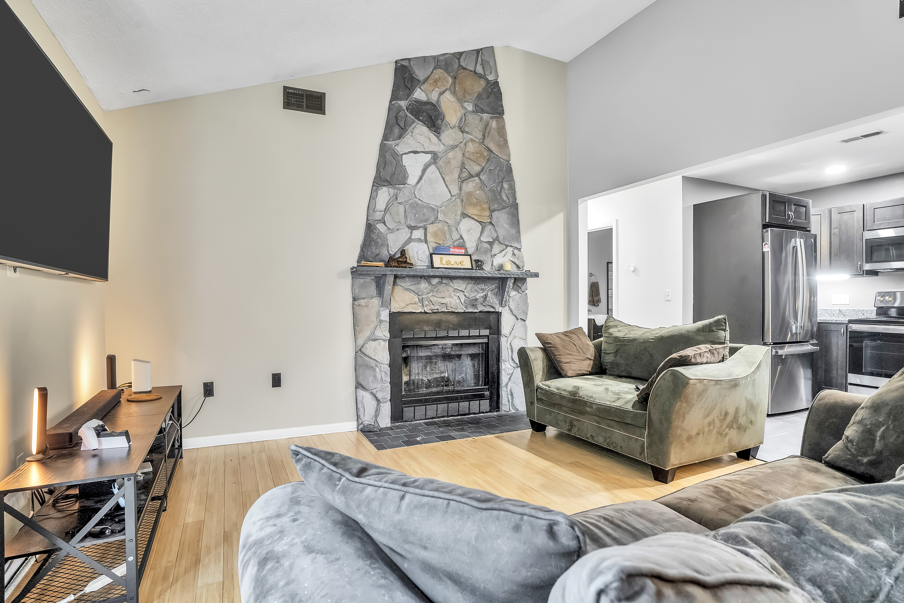 751 West Main Street, Unit G Cheshire, CT 06410 - Photo 10 of 38 a living room with furniture a fireplace and a flat screen tv