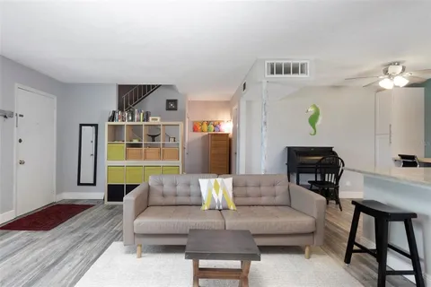a living room with furniture and a wooden floor
