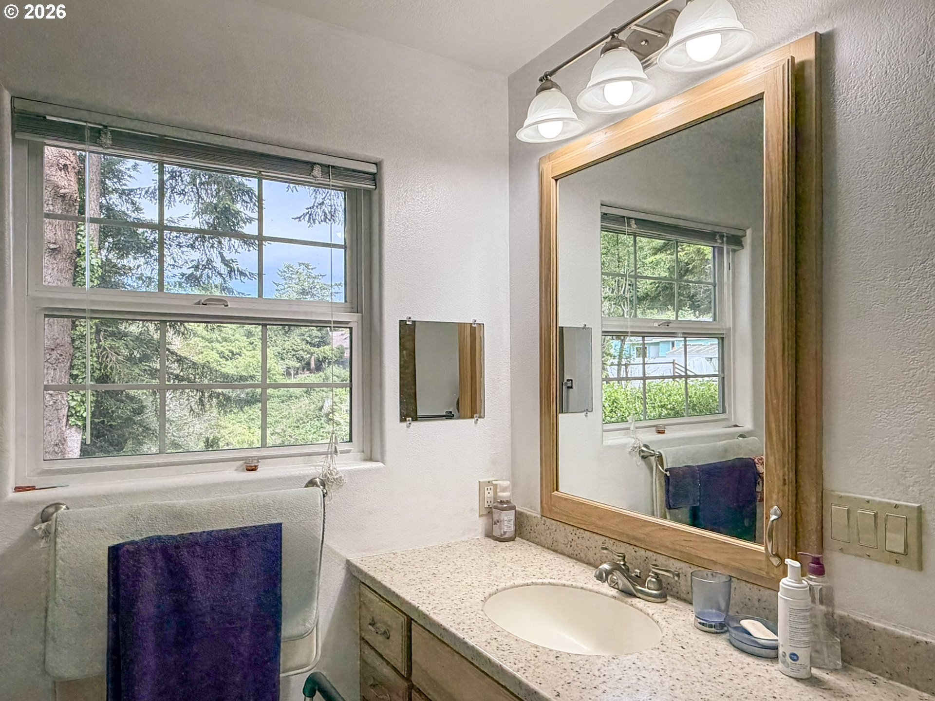 1372 Hampton Road Brookings, OR 97415 - Photo 27 of 42 a bathroom with a granite countertop sink vanity mirror and next to a window
