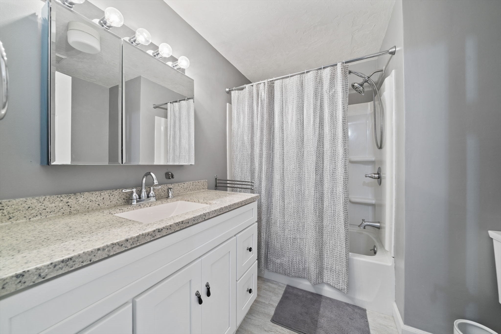 4 F Franklin Square, Unit 4F Randolph, MA 02368 - Photo 17 of 26 a bathroom with a granite countertop sink and a mirror