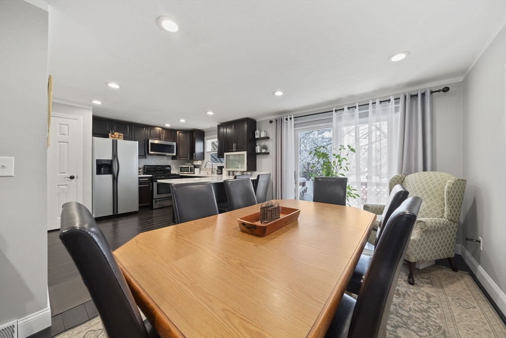 4 F Franklin Square, Unit 4F Randolph, MA 02368 - Photo 7 of 26 a kitchen with stainless steel appliances granite countertop a stove a refrigerator a kitchen island a table and chairs