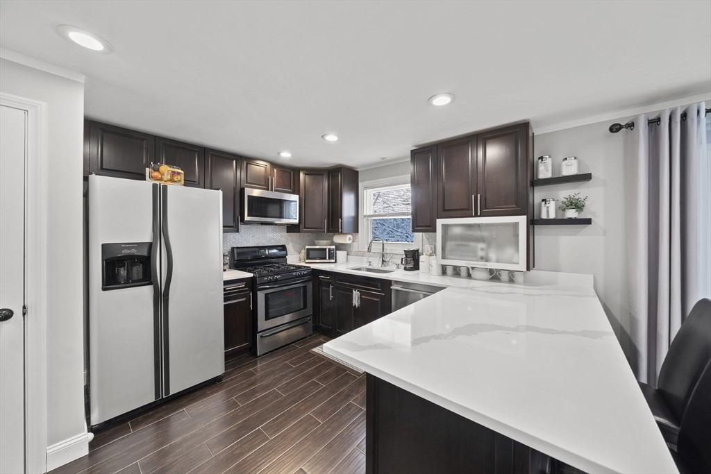 4 F Franklin Square, Unit 4F Randolph, MA 02368 - Photo 9 of 26 a kitchen with stainless steel appliances a refrigerator stove microwave and sink