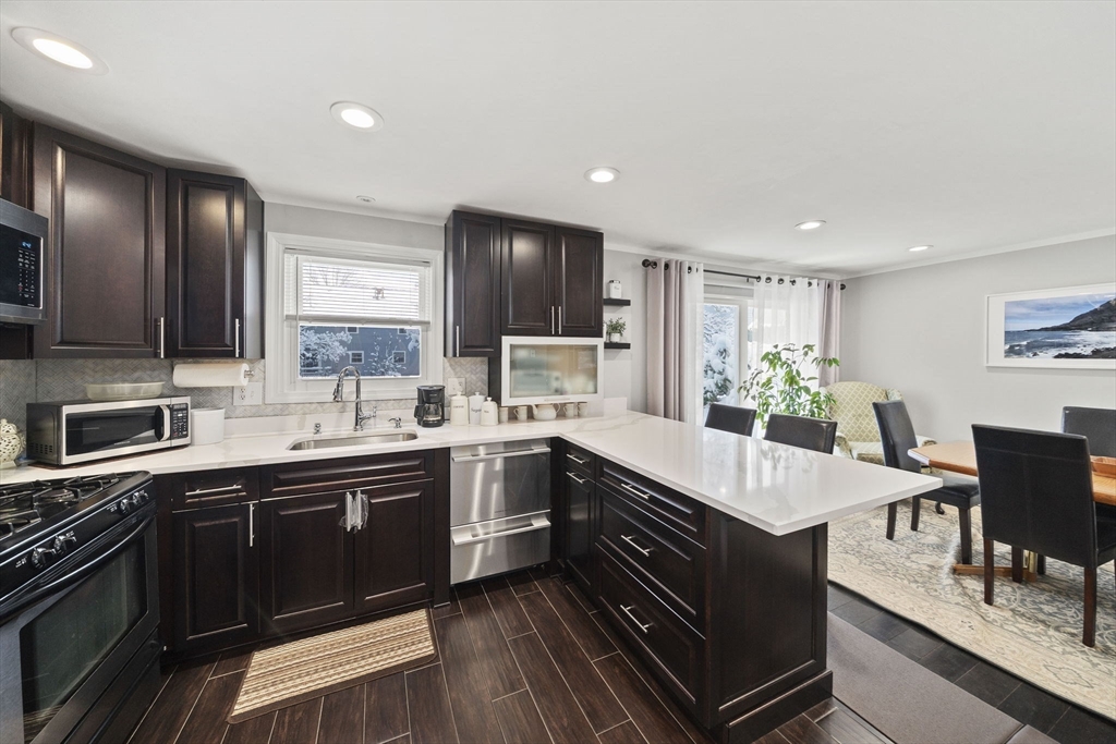 4 F Franklin Square, Unit 4F Randolph, MA 02368 - Photo 10 of 26 a large kitchen with stainless steel appliances granite countertop a sink and cabinets