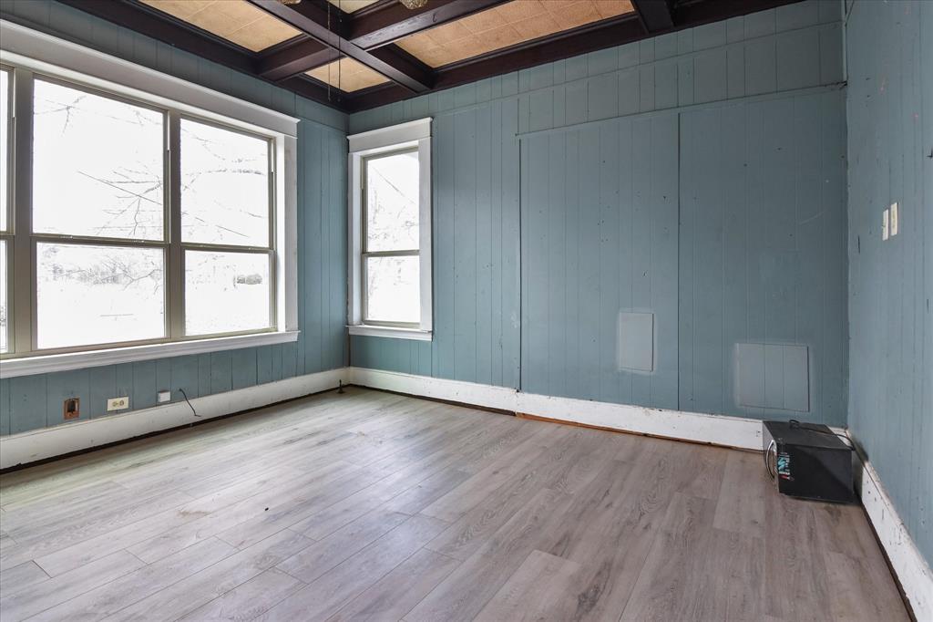 738 1st Street Southwest Paris, TX 75460 - Photo 7 of 25 Unfurnished room with coffered ceiling, wood walls, and light wood-type flooring
