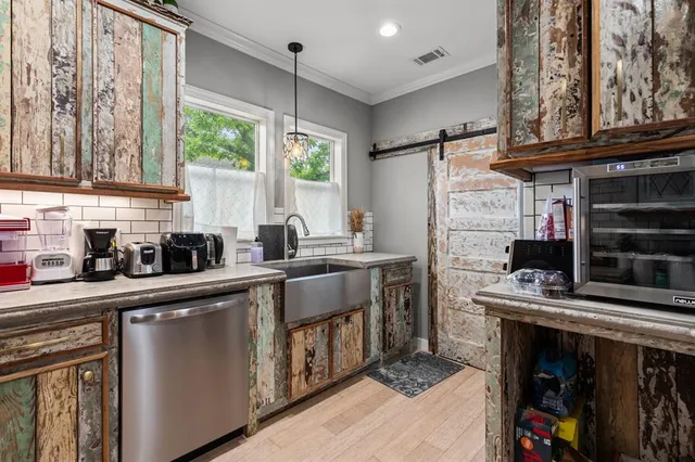 a kitchen with stainless steel appliances a stove a sink and a microwave